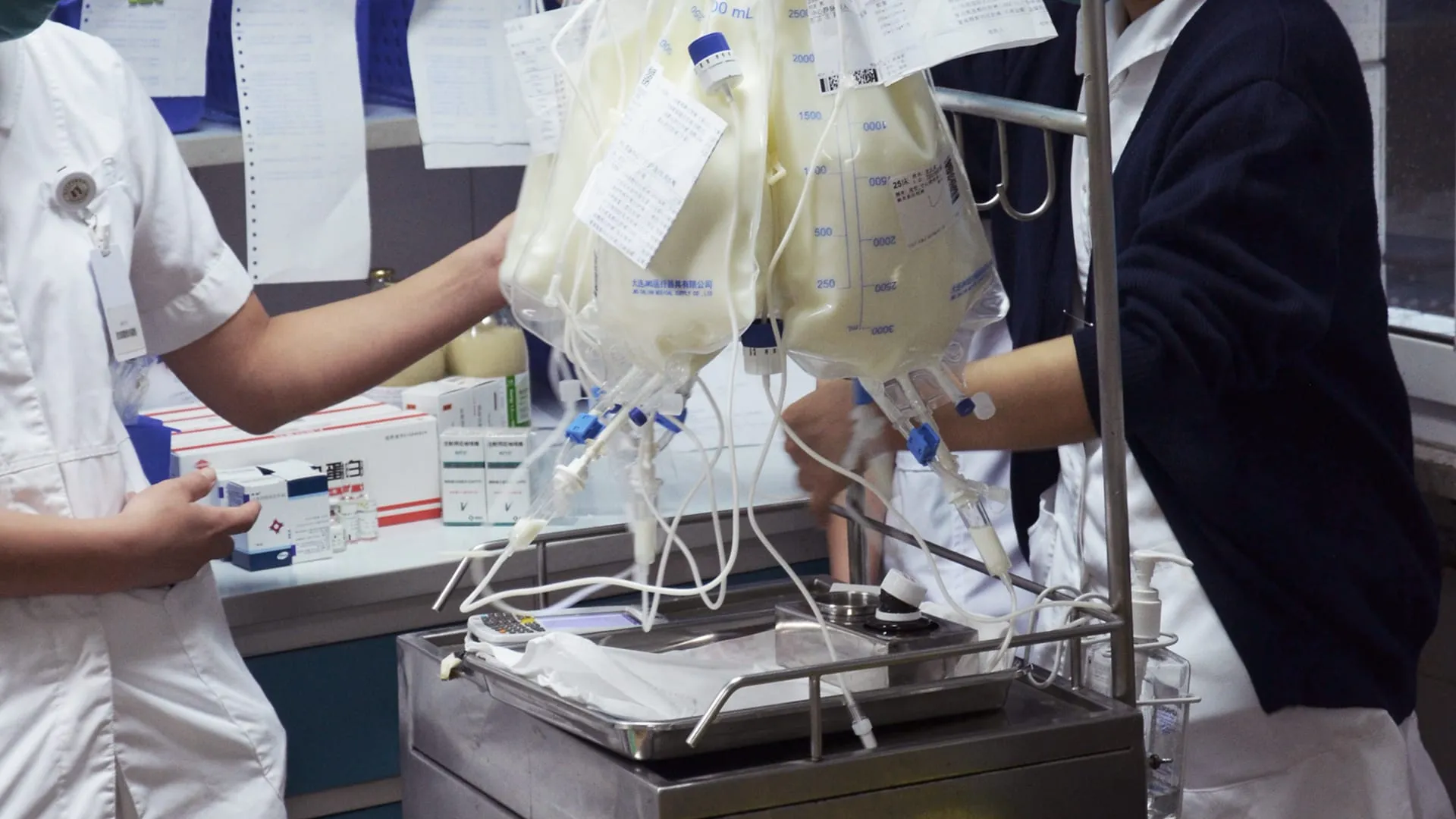 Zwei Pflegekräfte in einem klinischen Umfeld handhaben Infusionsbeutel und Medizinprodukte bei einer Nutzungskontextanalyse