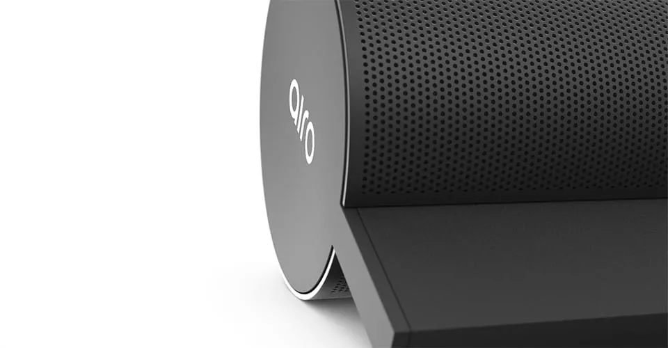 Nahaufnahme des zylindrischen AIRO Soundbar-Endes mit perforiertem Lautsprechergitter und Logo auf weißem Hintergrund