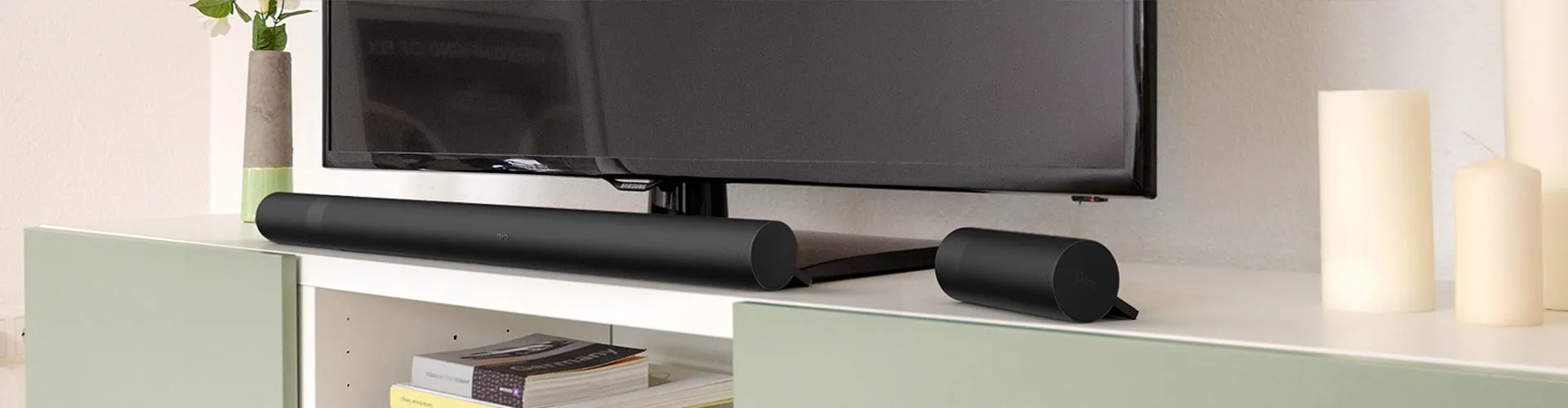 AIRO Soundbar mit zwei abgekoppelten Bluetooth-Satellitenlautsprechern auf einem Wohnzimmer-TV-Schrank unter einem Flachbildfernseher