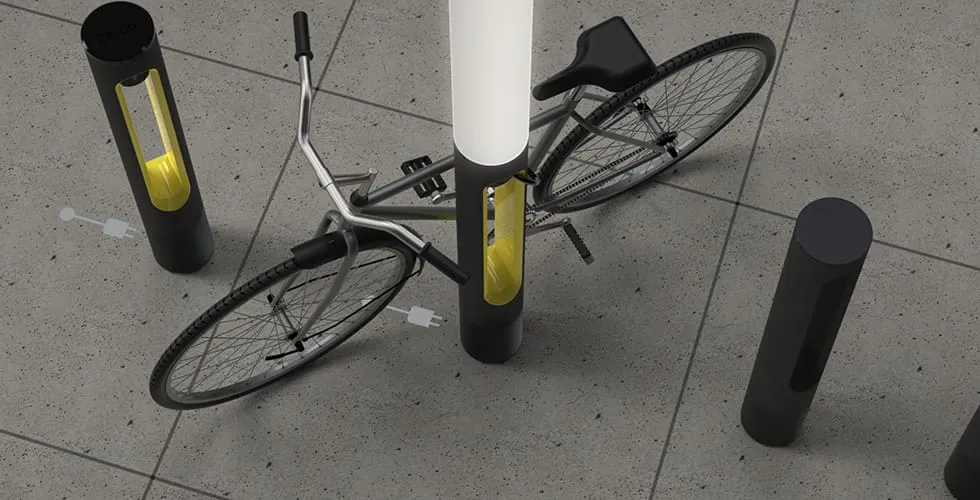 Vogelperspektive auf ein Fahrrad, das an einer SMARTPOLE E-Bike-Ladestation auf einem Stadtpflaster gesichert ist