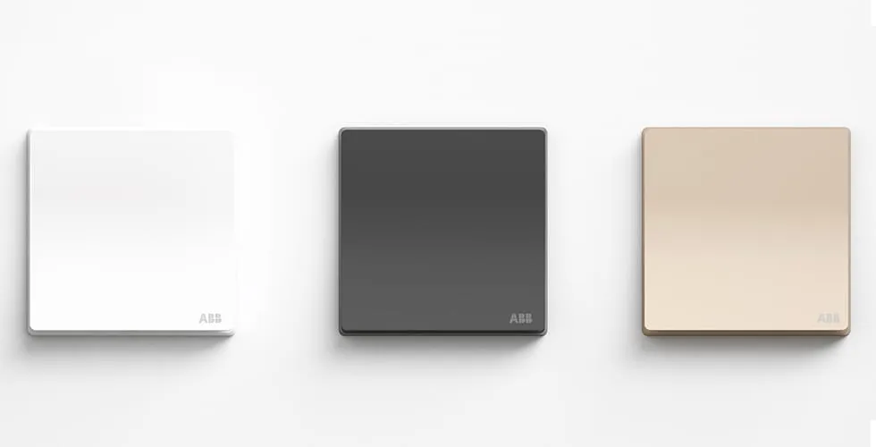 ABB XUAN ZHI Schalter in Weiß, Graphit und Champagnergold nebeneinander auf neutralem Hintergrund