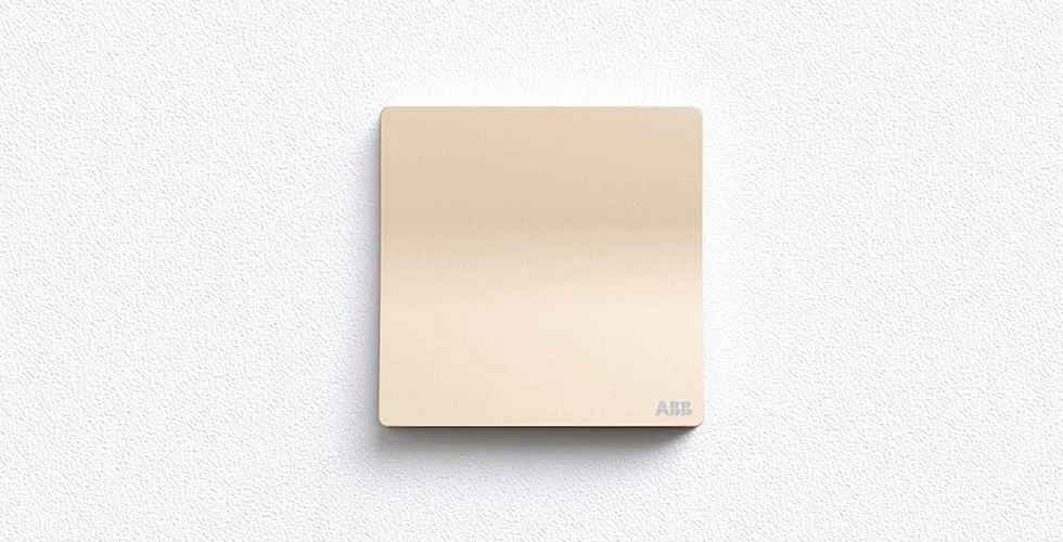 Einzelner ABB XUAN ZHI Schalter in Champagnergold, zentriert vor einer weichen texturierten hellen Wand