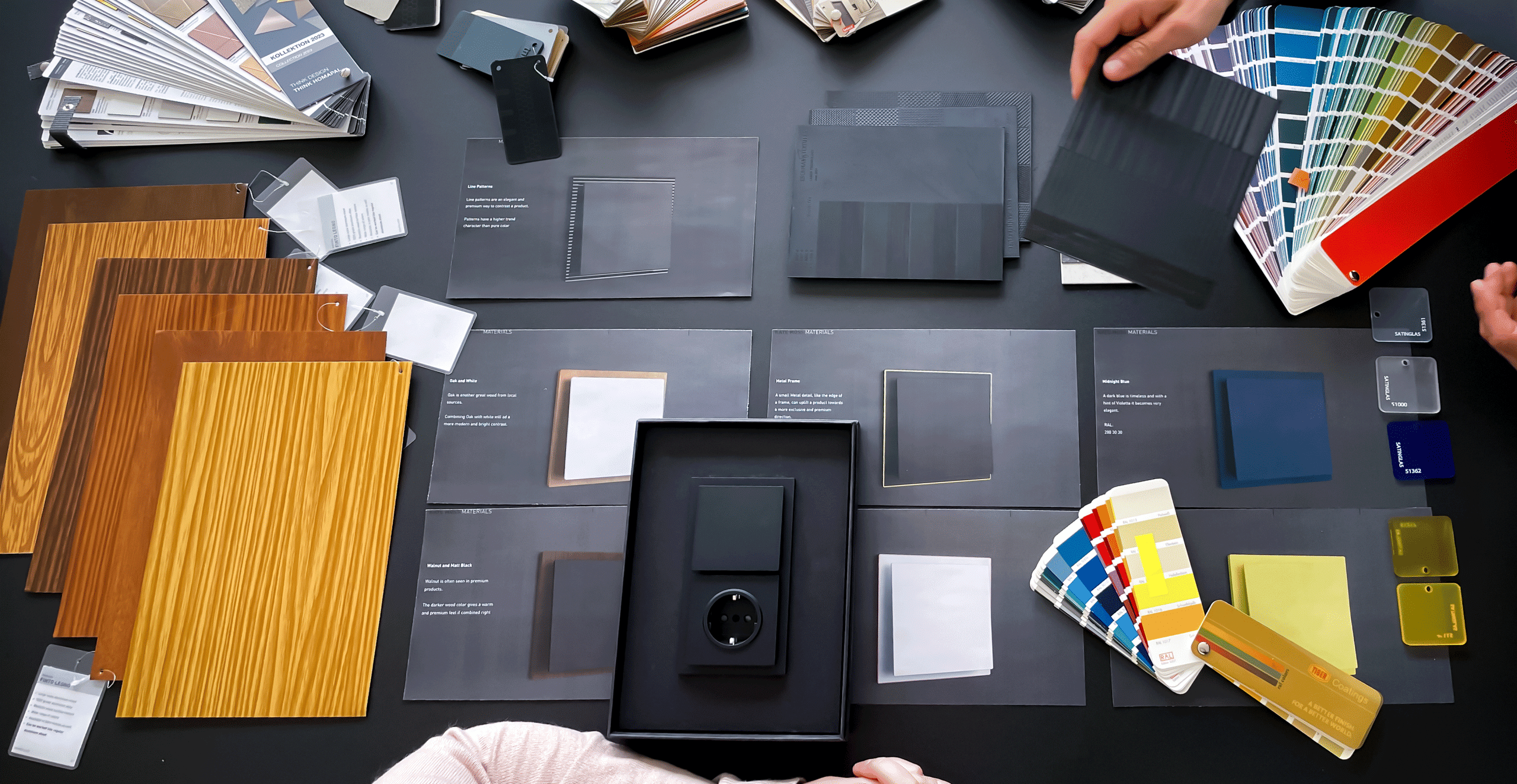 CMF-Designsession für Busch-art linear von Busch-Jaeger — Materialmuster, Holzfurniere und Farbfächer auf einem Arbeitstisch
