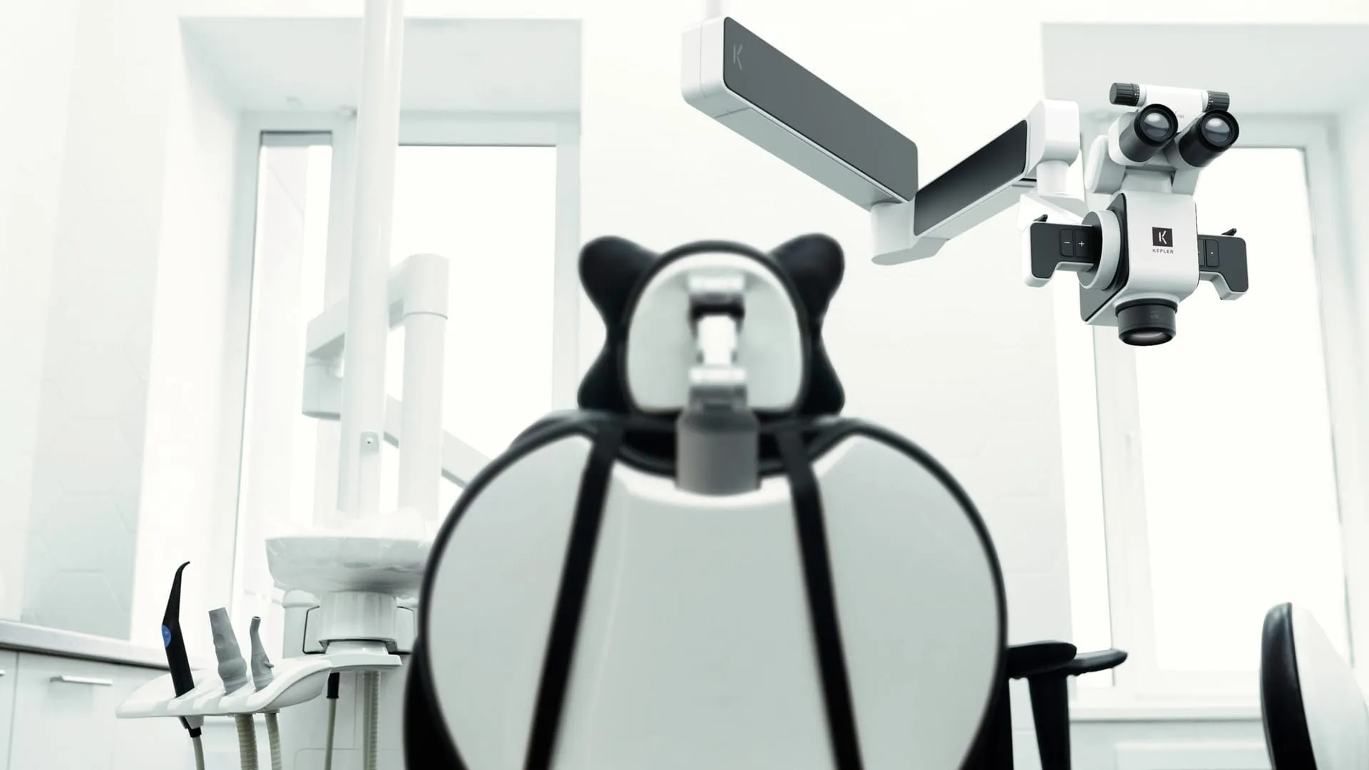 KEPLER Dentalmikroskop an einem Deckenarm über einem Behandlungsstuhl in einem hellen, modernen Behandlungsraum